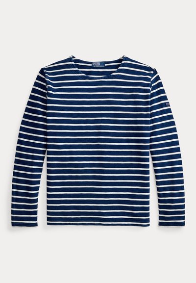 Μακρυμάνικο μπλε σκούρο μπλουζάκι με λευκές οριζόντιες ρίγες, στρογγυλή λαιμόκοψη, μαλακό βαμβακερό ύφασμα και λογότυπο στο αριστερό μανίκι.