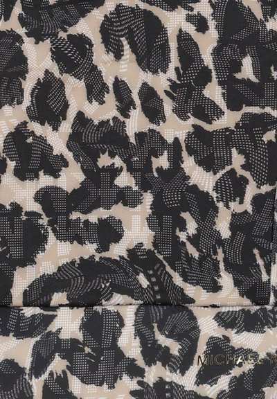 Tissu imprimé léopard en noir et beige, présentant un motif texturé avec des lignes douces et des accents de points. Comprend un détail de logo métallique.