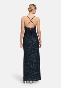 Navyblaues Paillettenabendkleid mit figurbetontem Schnitt, offenem Rücken und überkreuzten Trägern sowie bodenlangem Design. Glatte Textur mit Schimmer.