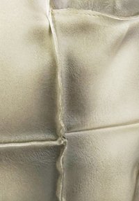 Metalen zilveren leren stof met een gladde textuur, met zichtbare naden en een licht gekreukelde uitstraling, wat een moderne look creëert.