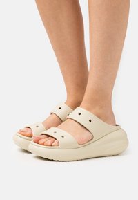 Sandali platform beige realizzati in gomma liscia, con fasce larghe, punta arrotondata e fori di ventilazione. Suola testurizzata per una buona aderenza.