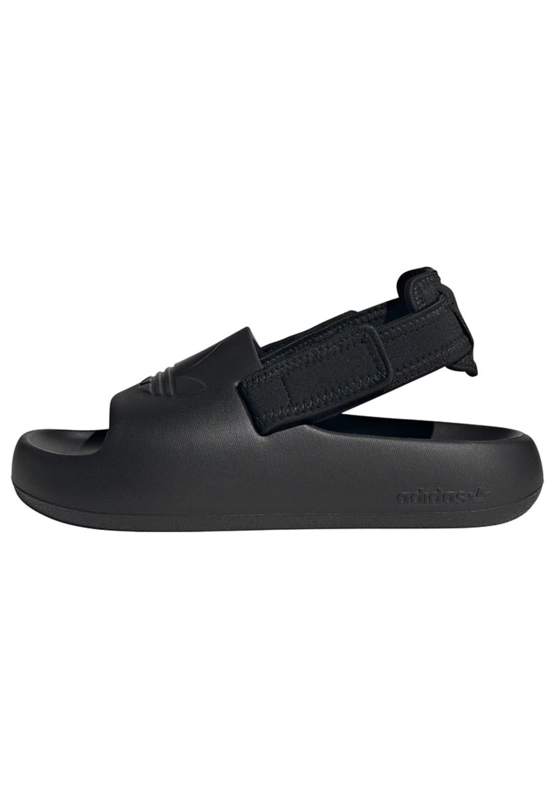 Black sandal with an open toe design, elastic strap, and textured material. Features a molded shape and logo detail on the side.