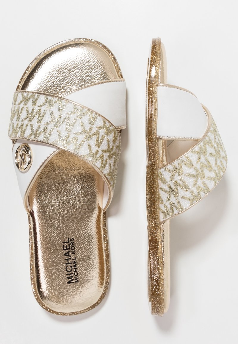 Paire de sandales à enfiler Michael Kors dorées et blanches avec des brides logo pailletées et des semelles métalliques, vues de dessus et de côté.