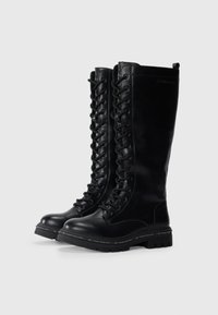 Bottes noires montant jusqu'aux genoux en cuir lisse, avec un laçage sur le devant, un bout rond et une semelle en caoutchouc texturé avec un logo.