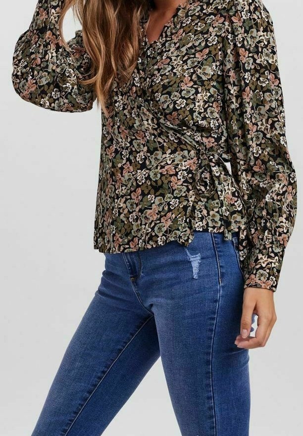 Blouse à encolure cache-coeur en vert foncé avec de longues manches bouffantes, comportant un mélange de petites fleurs roses, blanches et bleues, ainsi qu'un détail de lien sur le côté.