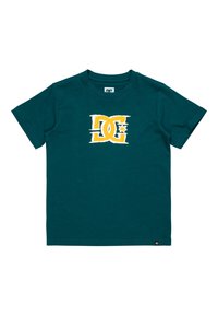 Teal farvet bomulds t-shirt med korte ærmer, der har et hvidt og gult DC-logo designet på forsiden. Klassisk crew neck stil.