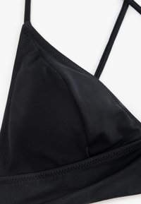Top bikini nero a forma triangolare, realizzato in tessuto liscio. Presenta sottili spalline regolabili e dettagli cuciti lungo i bordi.