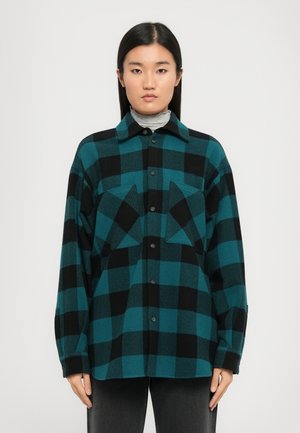 Teal og svart rutete flanellskjorte, knapper foran, spredt krage, to brystlommer, lange ermer med knappede mansjetter.