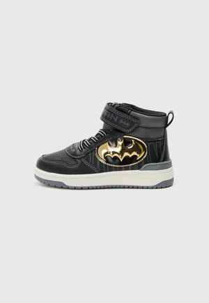 Baskets montantes noires pour enfants avec logo Batman doré, accents gris, fermeture Velcro, semelle blanche et languette au talon.