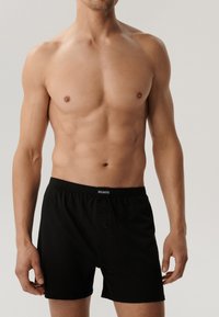 Czarne bawełniane bokserki z guzikowym zapięciem, elastycznym paskiem i nazwą marki "ATLANTIC" nadrukowaną z przodu. Gładka faktura.