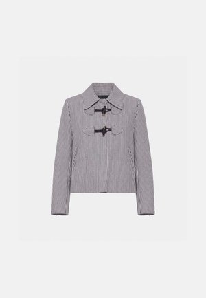 Veste rayée noire et blanche avec large col, deux fermetures à bascule noires à l'avant, manches longues et motif à rayures verticales.