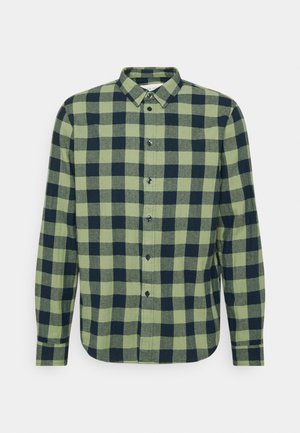 Chemise en flanelle à carreaux verts et marine, à manches longues, avec col boutonné et fermeture à boutons à l'avant. Tissu texturé avec des détails de motif à carreaux.