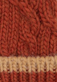 Knit wool fabric featuring a deep orange color with a textured cable pattern, accented by a horizontal cream band at the bottom.