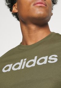 adidas Sportswear ESSENTIALS SINGLE LINEAR EMBROIDERED - Apdrukāts T-krekls - olive strata