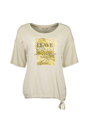 Crème kleurige top met korte mouwen en een losvallende pasvorm, voorzien van een gele en zwarte zebra print graphic en tekst, met een geraffineerde zoom met een trekkoord detail.