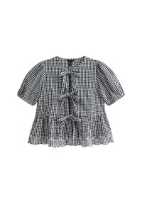 Blusa de cuadros vichy en blanco y negro con mangas cortas abullonadas, tres lazos delanteros y un borde de encaje en el dobladillo. Tejido de algodón, corte relajado.