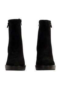 Botines de ante negros con un diseño elegante, que presentan una textura suave, punta redondeada y cremalleras en los laterales para facilitar su uso. Suelas de goma planas.
