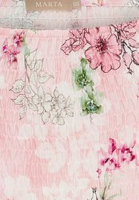 Blomstermønstret stof med en pink baggrund, der har grønne og pink blomster. Struktureret, samlet design. Etiket siger "MARTA."