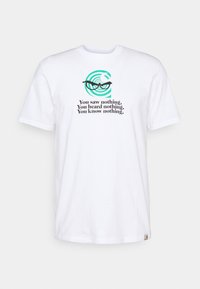 Camiseta blanca de algodón con un diseño gráfico que presenta un patrón en espiral, gafas y el texto: "No viste nada. No oíste nada. No sabes nada."