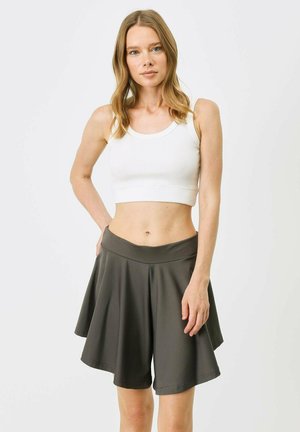 Dark gray flowy shorts made of lightweight fabric with a wide waistband and a relaxed silhouette, paired with a white ribbed crop top.
