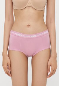Roza bombažna hipsterska spodnja perila z mehkimi elastičnimi pasom z belim logotipom Puma. Gladka tekstura in preprost dizajn brez vzorcev.
