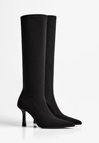 Czarne botki z materiału do kolan, z ostrym noskiem, smukłym fasonem i błyszczącym wysokim obcasem. Gładka tekstura z minimalnymi szwami.