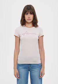 T-shirt rosa chiaro a maniche corte con scollo rotondo e un logo ricamato con filo metallico sul petto. Tessuto in cotone morbido.
