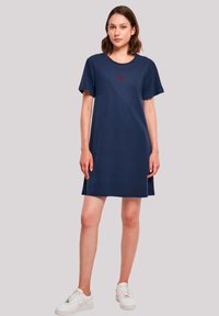 Navyblaues T-Shirt-Kleid mit kurzen Ärmeln und rundem Ausschnitt, mit einem roten Herz-Graphic auf der Brust. Hergestellt aus weichem Baumwollstoff.