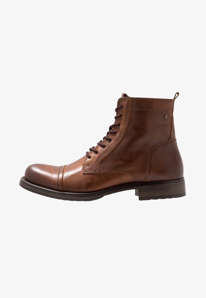 Bottine en cuir marron avec lacets à l'avant, bout renforcé, languette au talon et petit talon empilé sur fond blanc.