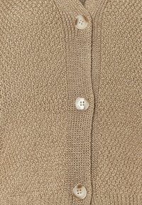 Beige gestrickter Cardigan mit V-Ausschnitt und vier hellen Knöpfen. Die Textur ist weich mit einem lockeren Strickmuster.