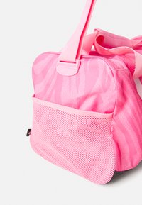 Rosa stoffpose med et teksturert zebra-mønster, med en mesh-sidelomme, solide stropper og avrundede kanter.
