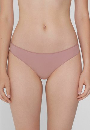 Brown-pink bikini bottoms with a smooth texture, minimal coverage, and a thin waistband. Seam detailing along edges. Medium rise design.