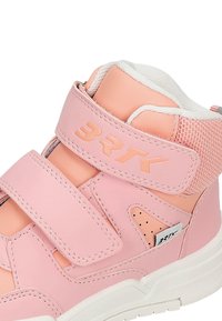 Baskets montantes roses avec une tige en cuir lisse, des sangles Velcro, des accents en mesh, une semelle blanche contrastante et des perforations sur les côtés.