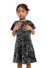 Abito nero corto coperto di paillettes. Maniche corte e scollatura rotonda. L'abito ha una forma svasata e riflette la luce grazie alle paillettes.