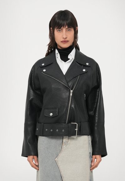 Veste en cuir noir à finition texturée, fermeture éclair sur le devant, grand col, boutons-pression et large ceinture avec boucle argentée.