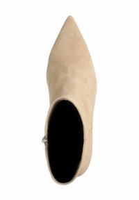 Bottine en suède beige à bout pointu et texture lisse, avec une fermeture éclair sur le côté et un intérieur noir.
