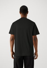Black cotton t-shirt with short sleeves and a round neckline, featuring a smooth texture and a simple back design.