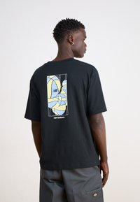 Black cotton t-shirt featuring a colorful graphic print on the back in blue and yellow, with a relaxed fit and short sleeves.