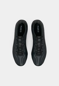 Μαύρα αθλητικά παπούτσια με κομψό σχέδιο, υφή στην επιφάνεια, λεπτά κορδόνια και εμφανές λογότυπο στις εσωτερικές σόλες, σε θέαση από επάνω.