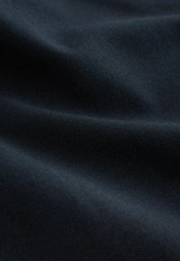 Tissu bleu marine foncé avec des plis subtils et une texture douce et lisse.