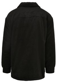 Zwarte corduroyjas met een relaxte pasvorm, voorzien van een kraag, ribbeltextuur, elastische manchetten en platte naden op de rug.