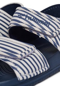 Paski niebiesko-kremowe sandały na slides z rzepami, teksturowaną wkładką i gumową podeszwą. Szczegóły logo na pasku.