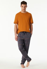 Orange cotton t-shirt with short sleeves and loose-fit gray plaid pants featuring orange and white lines, elastic waistband, and straight legs.