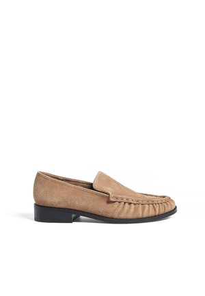 Suedesneakers i ljusbrun med rund tå, sydda detaljer och en låg svart klack för stabilitet och komfort.