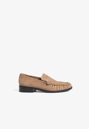 Mocassins en daim marron clair avec un bout arrondi, des détails brodés et un petit talon noir en bloc pour plus de stabilité et de confort.