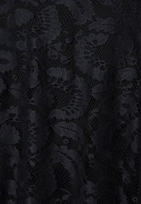 Tessuto di pizzo nero con intricate fantasie floreali e un aspetto delicato e strutturato, caratterizzato da una lavorazione sottile e aperta.