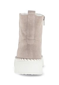 Grå ruskinds ankelstøvle med en hvid platformssål, der har en lynlås i siden og quiltede detaljer på bagsiden. Fluffy indvendig foring synlig.