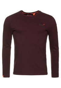 Bordeaux pitkähihaine T-paita, jossa on pyöreä pääntie, pehmeä rakenne, hienovarainen logo yksityiskohtana rinnassa ja pieni brändilogo helman kohdalla.