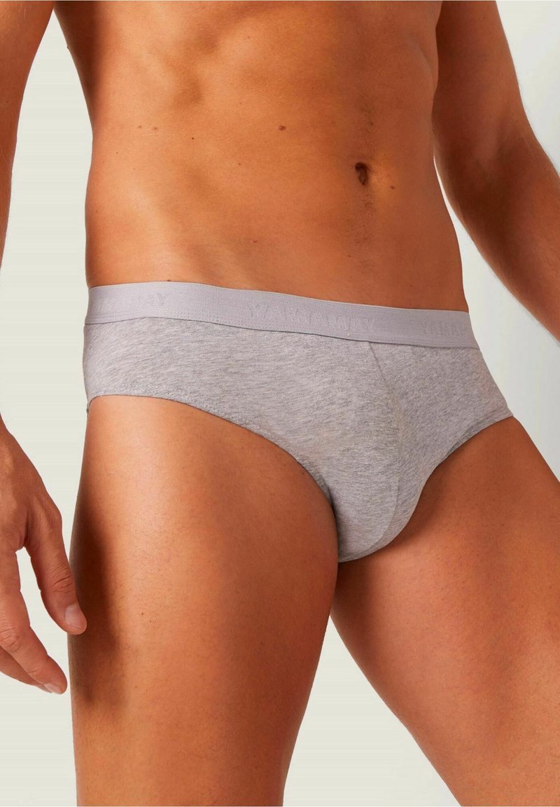 Graue Baumwollslips mit einem weichen elastischen Bund, die eine glatte Textur und eine enge Passform an Hüften und Oberschenkeln bieten.