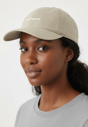 Beige baseball cap with a curved brim, featuring white "carhartt" embroidery on the front. Smooth fabric and a classic design.